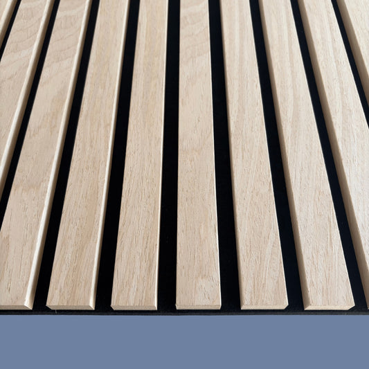 Detailed close-up of Vantaa light oak wood slat acoustic panel texture, showing precise vertical slats on blue background for superior sound absorption.