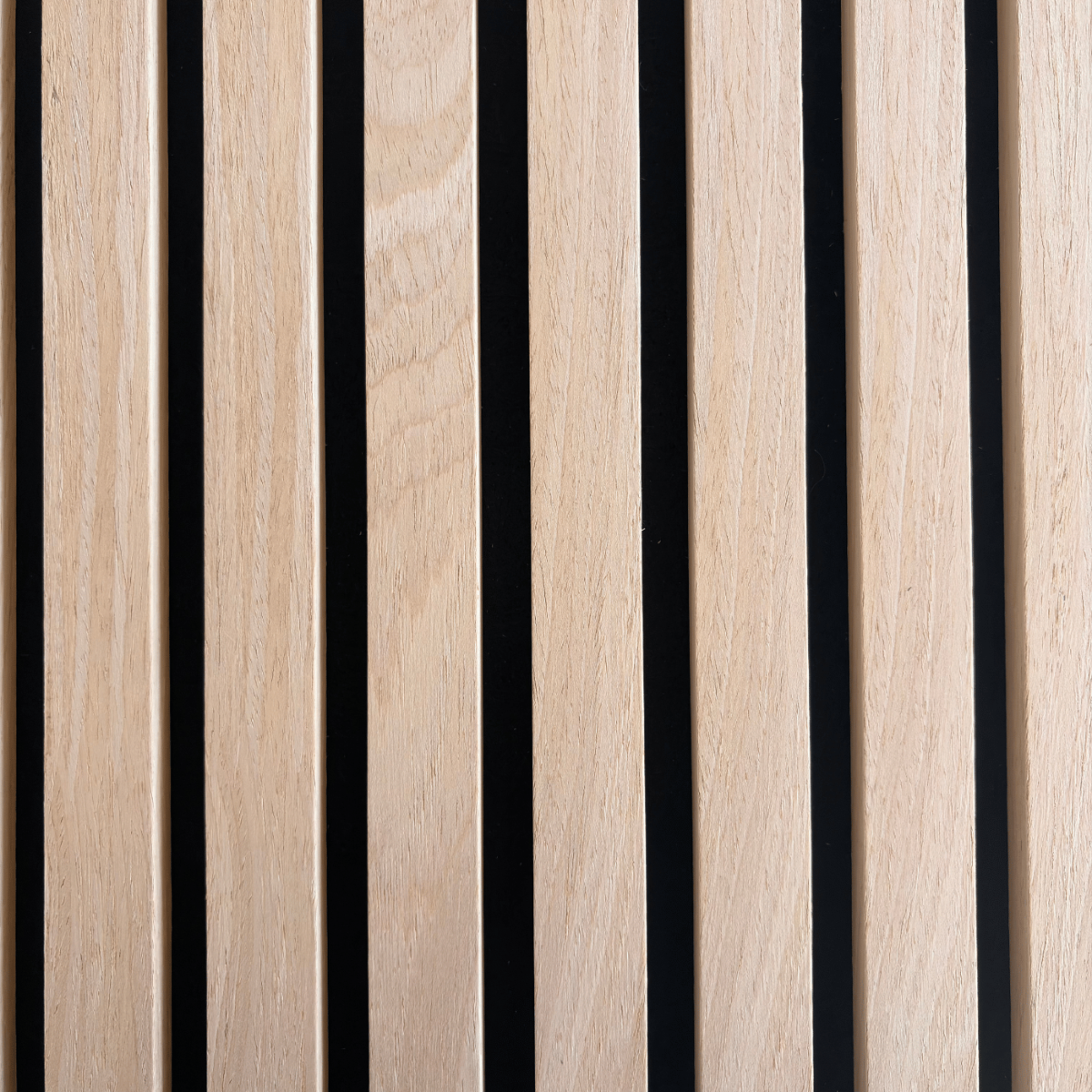 Extreme close-up detail of Vantaa acoustic wood slats in light oak finish, highlighting natural grain, precise spacing, and high-quality craftsmanship on black background.