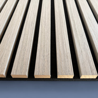 Detailed close-up of Vantaa Grey acoustic wood slats on blue background, highlighting texture, spacing, and premium sound-absorbing quality.